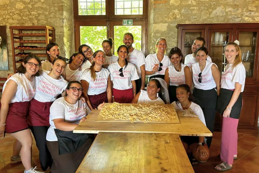 Amiche partecipano a un corso di cucina di pasta fresca durante un weekend di addio al nubilato nel Chianti.