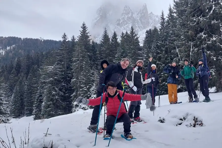 Gruppo di escursionisti WeHike sorridenti durante una ciaspolata sulle Dolomiti innevate